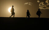 FILE - People walk along a trail as the sun sets, July 16, 2023, in Death Valley National Park, California (AP Photo/John Locher, File)
