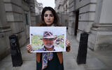 Roxanne Tahbaz holds a picture of her father, Morad Tahbaz, who is jailed in Iran, during a protest outside the UK Foreign, Commonwealth and Development Office in London, April 13, 2022. (Stefan Rousseau/PA via AP, File)