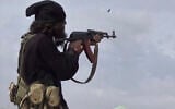 This file frame grab from video posted online March 18, 2019, by the Aamaq News Agency, a media arm of the Islamic State group, shows an IS fighter firing his weapon during clashes with the US-backed Syrian Democratic Forces (SDF) fighters, in Baghouz, Syria. (Aamaq News Agency via AP, File)