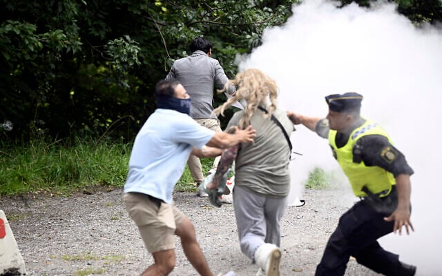 A counter-demonstrator extinguishes a Quran on fire outside the Iranian embassy, in Stockholm, Friday, August 18, 2023. A woman with a fire extinguisher on Friday raced toward the man who set fire to a Quran outside the Iranian Embassy in Stockholm but was stopped by plain clothes officers. (Fredrik Sandberg/TT News Agency via AP) A counter-demonstrator extinguishes a Quran on fire outside the Iranian embassy, in Stockholm, Friday, August 18, 2023. A woman with a fire extinguisher on Friday raced toward the man who set fire to a Quran outside the Iranian Embassy in Stockholm but was stopped by plain clothes officers. (Fredrik Sandberg/TT News Agency via AP)