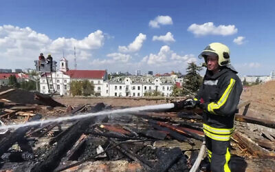Firefighters work on a roof of the Taras Shevchenko Chernihiv Regional Academic Music and Drama Theatre damaged by a Russian attack in Chernihiv, Ukraine, August 19, 2023. (Ukrainian Emergency Service via AP)