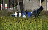 Russian servicemen inspect a part of a crashed private jet near the village of Kuzhenkino, Tver region, Russia, August 24, 2023. (AP Photo/Alexander Zemlianichenko)