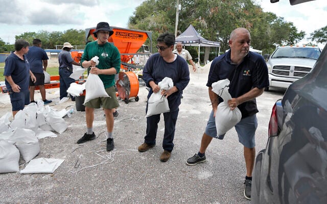Members of the Tampa, Florida, Parks and Recreation Deptment, help residents load sandbags in Tampa, Flordai, August 28, 2023. (Chris O'Meara/AP) Members of the Tampa, Florida, Parks and Recreation Deptment, help residents load sandbags in Tampa, Flordai, August 28, 2023. (Chris O'Meara/AP)