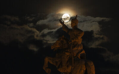 The supermoon rises near the equestrian statue of Damdin Sukhbaatar on Sukhbaatar Square in Ulaanbaatar, Mongolia, on August 30, 2023. (Ng Han Guan/AP)