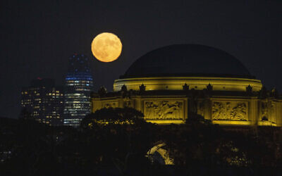 A blue supermoon rises between the Salesforce Tower and the Palace of Fine Arts in San Francisco, August 30, 2023. (Eric Risberg/AP)
