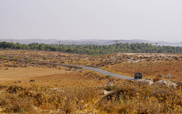 A military vehicle drives down a road in the southern West Bank, August 15, 2023. (Emanuel Fabian/Times of Israel)