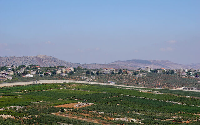 View of the Israeli military security barrier on the border with Lebanon, close to the northern town of Metula, with the Lebanese town of Kfarkela in the background, August 2, 2023. (Emanuel Fabian/Times of Israel) View of the Israeli military security barrier on the border with Lebanon, close to the northern town of Metula, with the Lebanese town of Kfarkela in the background, August 2, 2023. (Emanuel Fabian/Times of Israel)