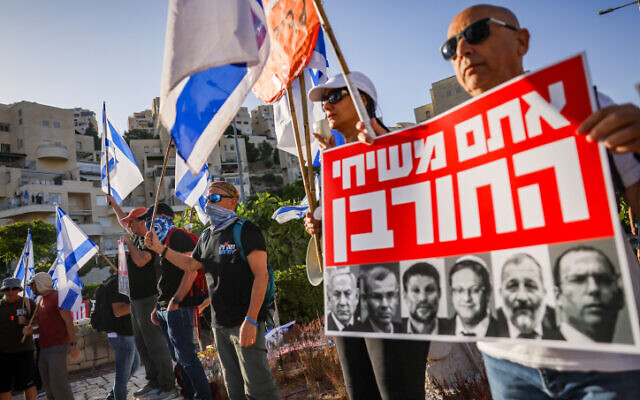 Activists protest against the government's planned judicial overhaul, outside the ultraconservative Har Hamor Yeshiva in the Jerusalem neighborhood of Har Homa, July 5, 2023. The sign, featuring leading members of the government, states 'You are the messianics of the destruction.' (Chaim Goldberg/Flash90) Activists protest against the government's planned judicial overhaul, outside the ultraconservative Har Hamor Yeshiva in the Jerusalem neighborhood of Har Homa, July 5, 2023. The sign, featuring leading members of the government, states 'You are the messianics of the destruction.' (Chaim Goldberg/Flash90)