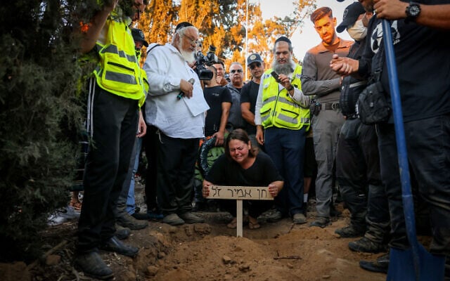Vered Assayag Amir and other mourners attend the funeral of her husband Chen Amir, a municipal patrolman who was shot dead in a terror attack in Tel Aviv a day earlier, at Kibbutz Reim, August 6, 2023. (Chaim Goldberg/Flash90) Vered Assayag Amir and other mourners attend the funeral of her husband Chen Amir, a municipal patrolman who was shot dead in a terror attack in Tel Aviv a day earlier, at Kibbutz Reim, August 6, 2023. (Chaim Goldberg/Flash90)