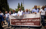 Arab citizens protest the budget cut in the Arab sector, outside the Finance Ministry in Jerusalem, on August 13, 2023. Banner reads 'Objecting to cutting budgets protesting for life.' (Chaim Goldberg/Flash90)