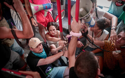 Activists protest against the decision to not operate the new Tel Aviv area light rail on the Sabbath, at the Elifelet Station in Tel Aviv on August 18, 2023. (Avshalom Sassoni/Flash90)