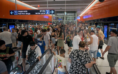 A crowd of passengers at a Tel Aviv light rail station on its first day of service, August 18, 2023. (Miriam Alster/Flash90)