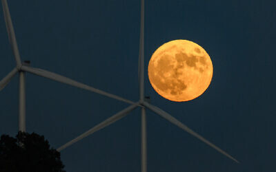 A blue supermoon rises over a station of wind turbines, in the Golan Heights, northern Israel, August 30, 2023.. (Ayal Margolin/Flash90)