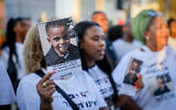 A woman holds up a photo of 4-year-old Rafael Adana, during a protest in Tel Aviv on August 30, 2023, calling for justice after he was killed in a hit-and-run in Netanya in May. (Chaim Goldberg/Flash90)