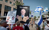 Protesters hold up signs against the government's judicial overhaul, during a rally in Tel Aviv on August 31, 2023. (Avshalom Sassoni/Flash90)