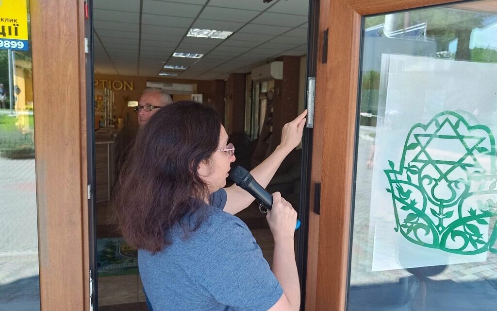 Rabbi Irina Gritsevskaya affixes a mezuzah to a building at Ramah Yachad in Ukraine at the start of the 2023 session. (Courtesy Midreshet Schechter via JTA)