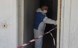 In this handout photo, a police officer investigates at an apartment in Haifa where a decomposing body was found in the wall, August 9, 2023. (Israel Police)
