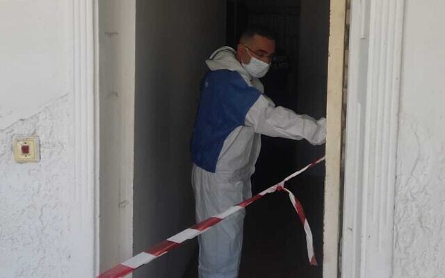 In this handout photo, a police officer investigates at an apartment in Haifa where a decomposing body was found in the wall, August 9, 2023. (Israel Police) In this handout photo, a police officer investigates at an apartment in Haifa where a decomposing body was found in the wall, August 9, 2023. (Israel Police)