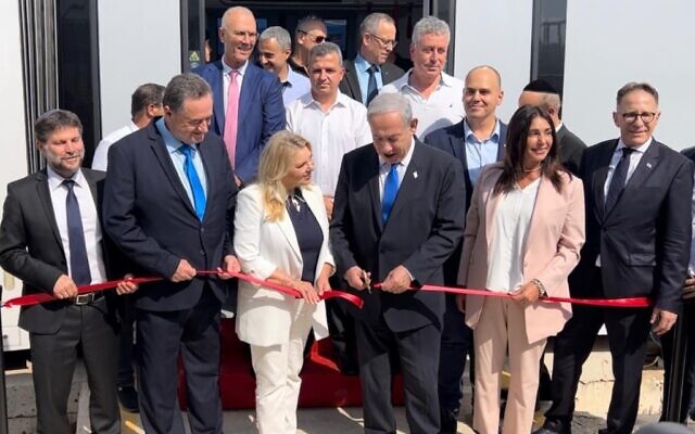Prime Minister Benjamin Netanyahu cuts a ribbon at the new Tel Aviv light rail line on August 17, 2023. (Courtesy)