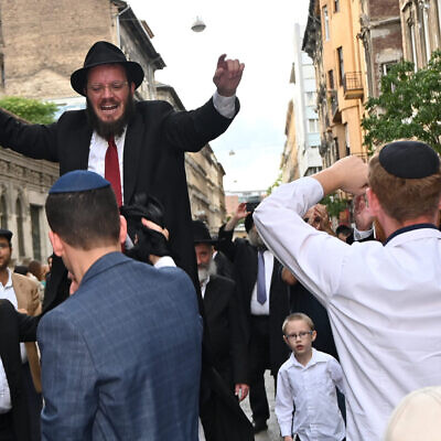 Rabbi Shmeul Oirechman dancing on the shoulders of other Jews at the opening of the Vorosmarty Street Synagogue in Budapest, Hungary, Aug. 27, 2021. (Cnaan Liphshiz)