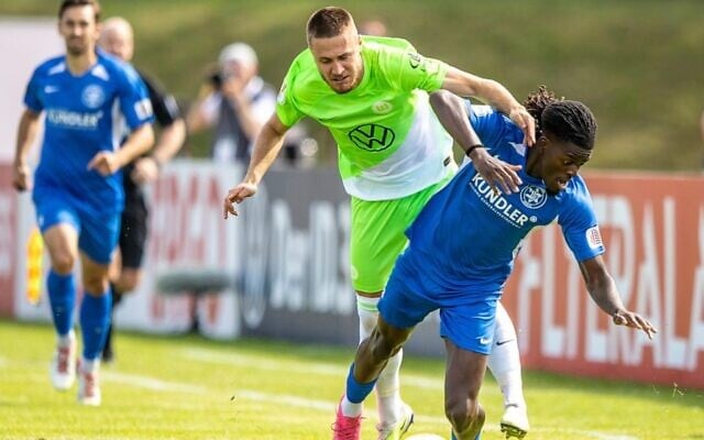 Wolfsburg's Mattias Svanberg, left, fights for the ball against TUS Makkabi's Brian Petnga during the German Soccer Cup match between TuS Makkabi and VfL Wolfsburg at Mommsenstadion stadium, Berlin, Sunday Aug. 13, 2023. (Andreas Gora/dpa via AP) Wolfsburg's Mattias Svanberg, left, fights for the ball against TUS Makkabi's Brian Petnga during the German Soccer Cup match between TuS Makkabi and VfL Wolfsburg at Mommsenstadion stadium, Berlin, Sunday Aug. 13, 2023. (Andreas Gora/dpa via AP)
