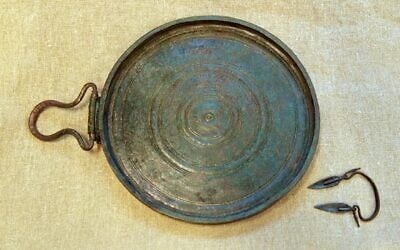 A rare bronze mirror discovered in the tomb of a Greek courtesan, along Hebron Road in Jerusalem, in a photo released on September 27, 2023. (Emil Aladjem/Israel Antiquities Authority)