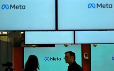 Visitors stand in front and next to screens displaying the Meta logo during a launch event at the corporate offices of Meta in Berlin on June 6, 2023. (Tobias Schwarz/AFP) Visitors stand in front and next to screens displaying the Meta logo during a launch event at the corporate offices of Meta in Berlin on June 6, 2023. (Tobias Schwarz/AFP)