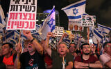 Protesters wave flags and placards during a demonstration against the Israeli government's judicial overhaul plan in Tel Aviv, on August 26, 2023. (JACK GUEZ / AFP)