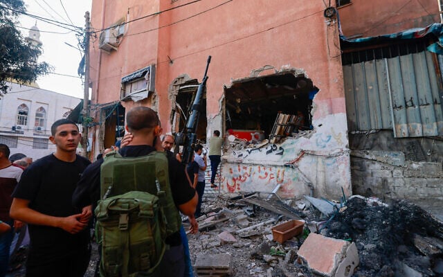 A Palestinian gunman and others inspect a damaged building in the Nur Shams refugee camp in the West Bank city of Tulkarem, after Israeli troops destroyed a cache of explosive devices, on September 5, 2023, (Jaafar ASHTIYEH / AFP) A Palestinian gunman and others inspect a damaged building in the Nur Shams refugee camp in the West Bank city of Tulkarem, after Israeli troops destroyed a cache of explosive devices, on September 5, 2023, (Jaafar ASHTIYEH / AFP)