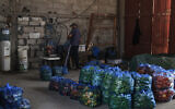 Vegetable produce that was originally headed to Israel via the Kerem Shalom commercial border crossing is unloaded at a warehouse in Rafah in the southern Gaza Strip on September 5, 2023.  (SAID KHATIB / AFP)