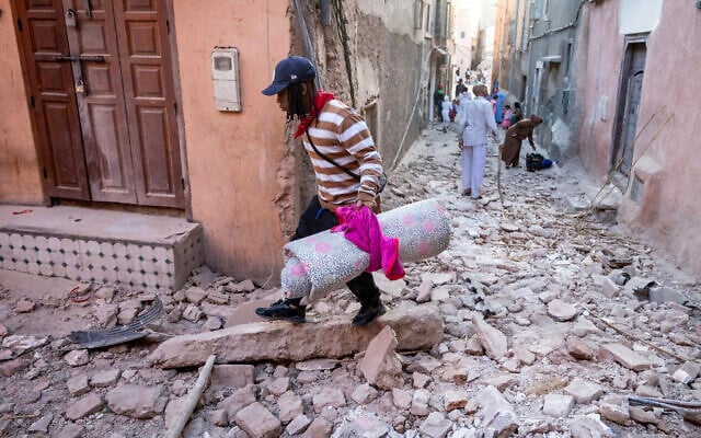 A man walks with his belongings through the rubble in an alleyway in the earthquake-damaged old city in Marrakesh on September 9, 2023.(Photo by FADEL SENNA / AFP) A man walks with his belongings through the rubble in an alleyway in the earthquake-damaged old city in Marrakesh on September 9, 2023.(Photo by FADEL SENNA / AFP)