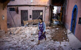 A woman walks through the rubble past earthquake-damaged houses in the old city in Marrakesh, Morocco on September 9, 2023. (Fadel Senna/AFP)