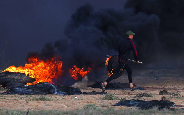 A Palestinian rioter burns tires during clashes with Israeli soldiers east of Rafah in the southern Gaza Strip near the Israel-Gaza border fence on September 23, 2023. (Said Khatib/AFP) A Palestinian rioter burns tires during clashes with Israeli soldiers east of Rafah in the southern Gaza Strip near the Israel-Gaza border fence on September 23, 2023. (Said Khatib/AFP)
