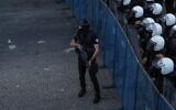Members of the Palestinian Authority security forces block a road as demonstrators rally in Ramallah in the West Bank on July 3, 2021, for a protest denouncing the PA in the aftermath of the death of activist Nizar Banat while in the custody. (Ahmad GHARABLI / AFP)