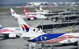 File: Malaysia Airlines planes taxi at a terminal while taking passengers at Kuala Lumpur International Airport in Sepang, Malaysia, on April 1, 2022. (AP Photo/Vincent Thian)
