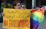 Supporters of the LGBT (Lesbian, Gay, Bisexual, and Transgender) community attend a sit-in to protest the ongoing criminalization of homosexuality and arbitrary arrests in front of Hobeich police station, in Beirut, Lebanon, Sunday, May 15, 2016. (AP/Hussein Malla)