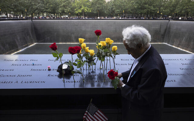Hagi Abucar puts flowers on the 9/11 Memorial during the commemoration ceremony on the 22nd anniversary of the September 11, 2001, terror attacks on Monday, Sept. 11, 2023, in New York. (AP/Yuki Iwamura)