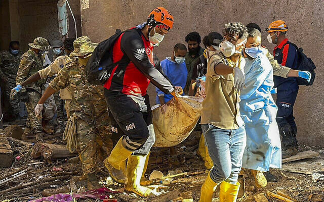 In this photo provided by Turkey's IHH humanitarian aid group, rescuers retrieve the body of a flooding victim in Derna, Libya, Wednesday, Sept.13, 2023. Search teams are combing streets, wrecked buildings, and even the sea to look for bodies in Derna, where the collapse of two dams unleashed a massive flash flood that killed thousands of people. (IHH via AP) In this photo provided by Turkey's IHH humanitarian aid group, rescuers retrieve the body of a flooding victim in Derna, Libya, Wednesday, Sept.13, 2023. Search teams are combing streets, wrecked buildings, and even the sea to look for bodies in Derna, where the collapse of two dams unleashed a massive flash flood that killed thousands of people. (IHH via AP)
