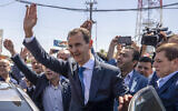 Syrian President Bashar Assad, center, waves to his supporters at a polling station during the Presidential elections in the town of Douma, in the eastern Ghouta region, near the Syrian capital Damascus, Syria, May 26, 2021. (AP Photo/Hassan Ammar, File)