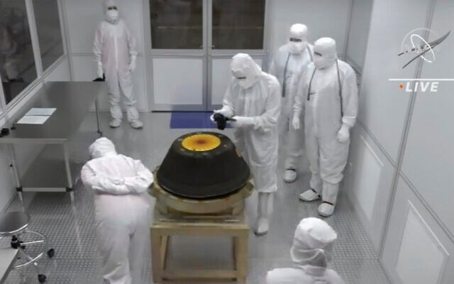 In this image from video provided by NASA, technicians in a clean room examine the sample return capsule from NASA's Osiris-Rex mission after it landed at the Department of Defense's Utah Test and Training Range on Sunday, Sept. 24, 2023. The sample was collected from the asteroid Bennu in October 2020. (NASA via AP) In this image from video provided by NASA, technicians in a clean room examine the sample return capsule from NASA's Osiris-Rex mission after it landed at the Department of Defense's Utah Test and Training Range on Sunday, Sept. 24, 2023. The sample was collected from the asteroid Bennu in October 2020. (NASA via AP)