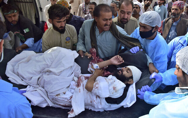 Paramedics and volunteers carry a man injured in a bomb explosion upon arrival at a hospital, in Quetta, Pakistan, Friday, Sept. 29, 2023. (AP/Arshad Butt)