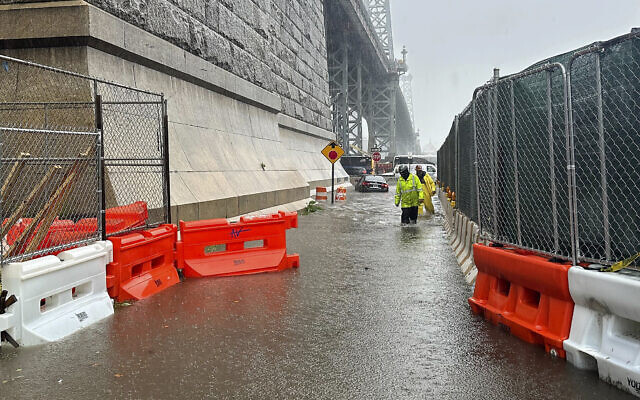 First responders wade through flood waters at the base of the Williamsburg Bridge, September 29, 2023, in New York. (AP Photo/Jake Offenhartz)