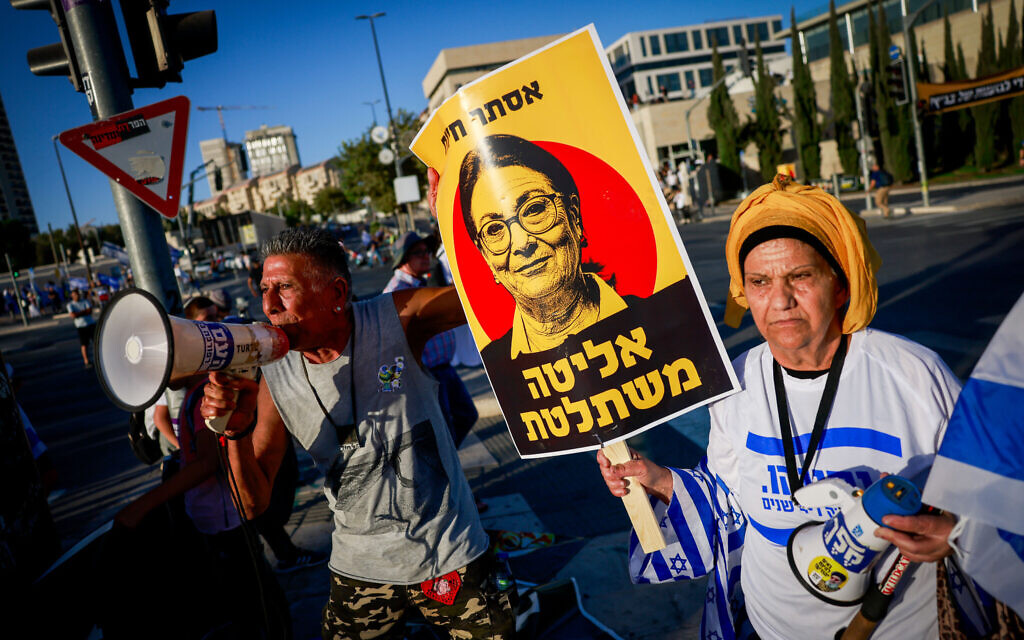 Right-wing Israelis, one carrying a sign showing Supreme Court President Esther Hayut and the slogan “The elite takes over,” attend a rally in support of the government's judicial overhaul, outside the Supreme Court in Jerusalem, on September 7, 2023. (Chaim Goldberg/Flash90) Right-wing Israelis, one carrying a sign showing Supreme Court President Esther Hayut and the slogan “The elite takes over,” attend a rally in support of the government's judicial overhaul, outside the Supreme Court in Jerusalem, on September 7, 2023. (Chaim Goldberg/Flash90)