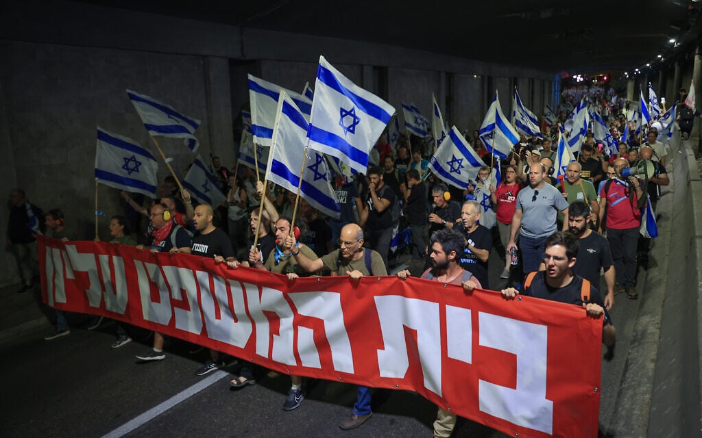 Anti-overhaul activists march from the Supreme Court to Prime Minister Benjamin Netanyahu's apartment in Jerusalem, on September 11, 2023. The banner reads: 'The court is supreme.' (Noam Revkin Fenton/Flash90)