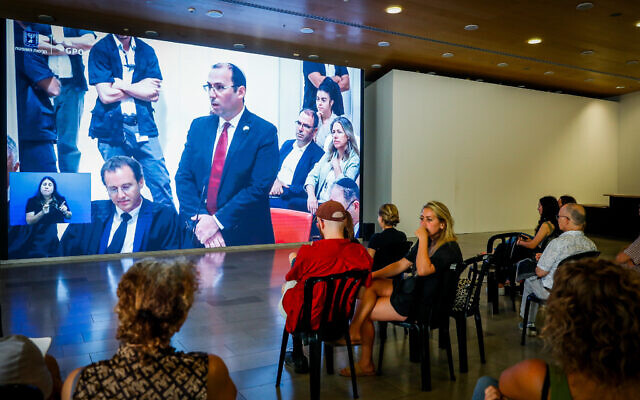 People watch a livestream of MK Simcha Rothman speaking during a High Court hearing on petitions against the government's reasonableness law, in Tel Aviv, September 12, 2023. (Miriam Alster/Flash90) People watch a livestream of MK Simcha Rothman speaking during a High Court hearing on petitions against the government's reasonableness law, in Tel Aviv, September 12, 2023. (Miriam Alster/Flash90)