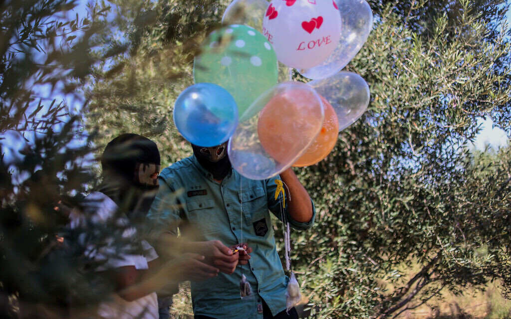 Palestinian youths launch incendiary balloons towards Israel near the border east of in Beit Lahia in the northern Gaza Strip, on September 26, 2023. (Atia Mohammed/Flash90)