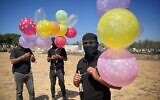 Masked Gazans prepare to launch fire-sparking balloons toward Israel in the Gaza Strip, September 23, 2023 (Palestinian social media)