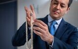 Christie's international head of jewelry Rahul Kadakia presents an item from the collection of Heidi Horten ahead of auction in Geneva, Switzerland, May 8, 2023. (Fabrice Coffrini/AFP via Getty Images via JTA)
