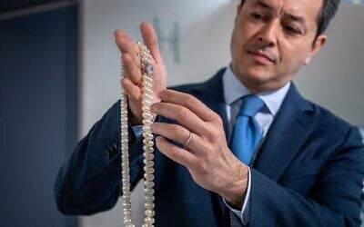 Christie's international head of jewelry Rahul Kadakia presents an item from the collection of Heidi Horten ahead of auction in Geneva, Switzerland, May 8, 2023. (Fabrice Coffrini/AFP via Getty Images via JTA)