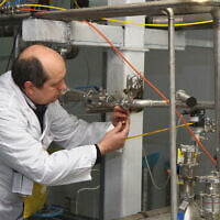 Illustrative: An unidentified International Atomic Energy Agency (IAEA) inspector disconnects the connections between the twin cascades for 20 percent uranium production at the nuclear research center of Natanz, some 300 kilometers south of Tehran, Iran, on January 20, 2014. (KAZEM GHANE/IRNA/AFP)